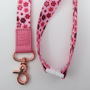 Floral patterned lanyard with pink clip and rose gold clasp on a light gray background