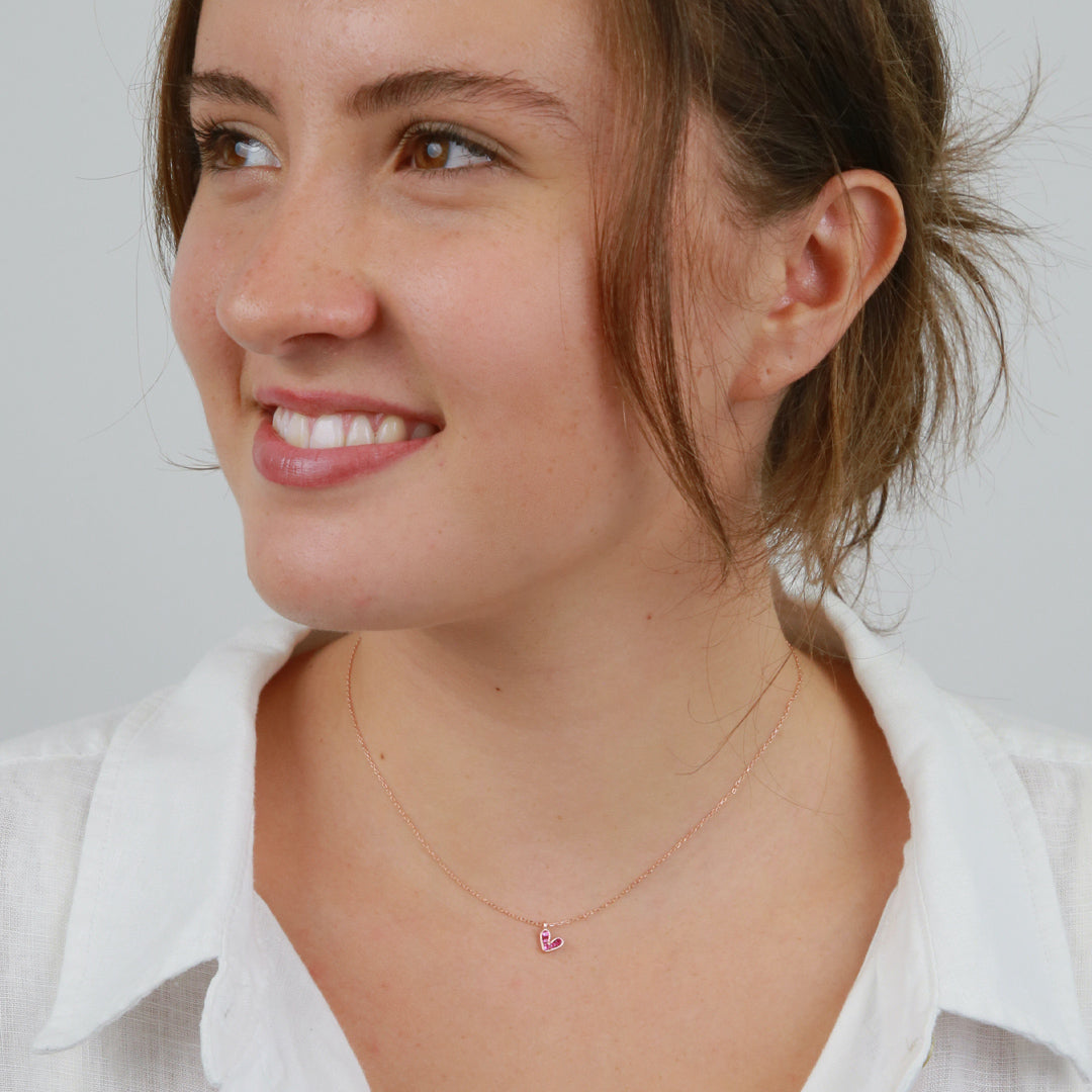 Girl wearing Pink heart pendant necklace sterling silver with 18K rose gold plating on gift card that has text that says so loved. 