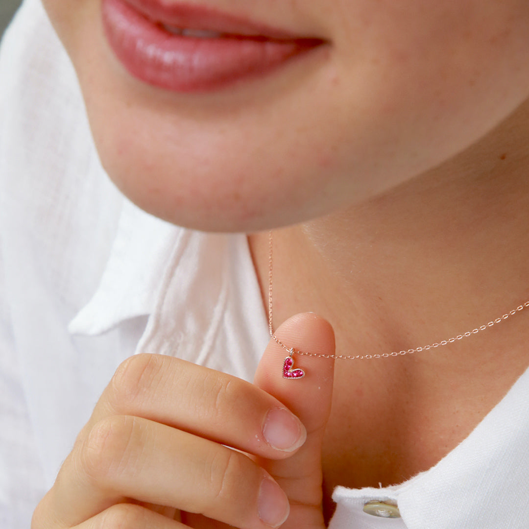 Pink heart pendant necklace sterling silver with 18K rose gold plating on gift card that has text that says so loved. 