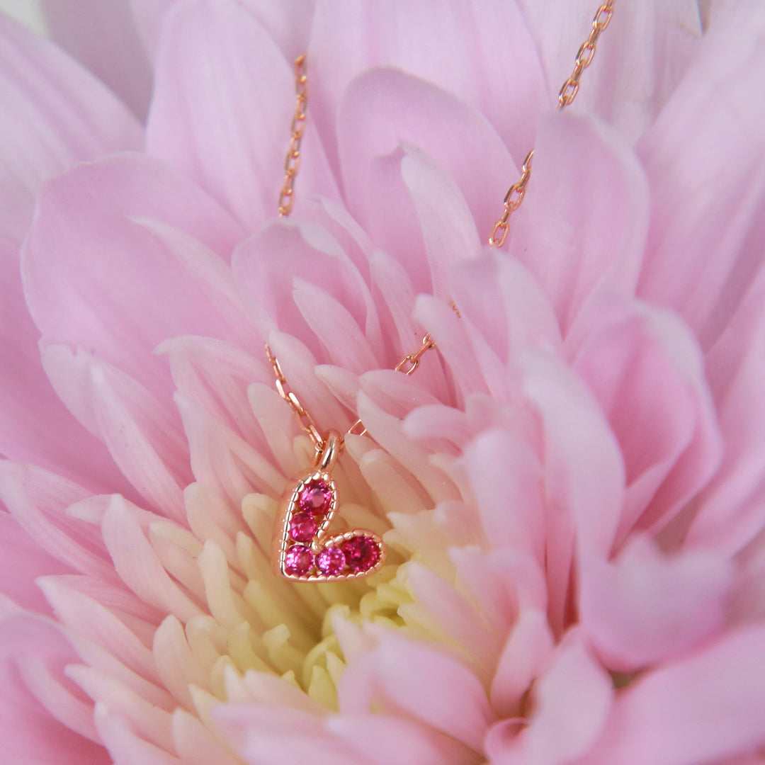 Pink heart pendant necklace sterling silver with 18K rose gold plating on gift card that has text that says so loved. 