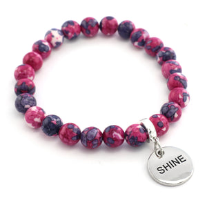 Beaded bracelet with a 'SHINE' charm on a white background