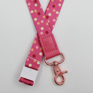 Be Kind embossed on a pink polka dot lanyard with pink trim and a lobster clasp.
