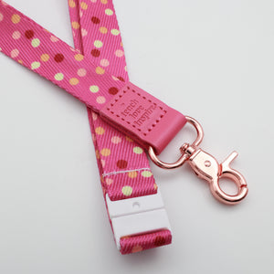 Teach Love Inspire embossed on a pink polka dot lanyard with pink trim and a lobster clasp.