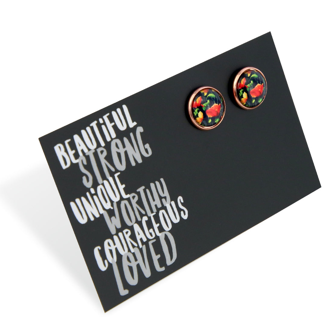 Floral patterned earrings on a black card with motivational text