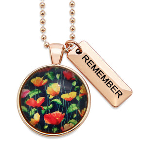 Necklace with floral pendant and 'REMEMBER' tag on a white background