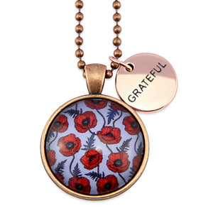 Necklace with red floral design pendant and 'GRATEFUL' tag on a white background