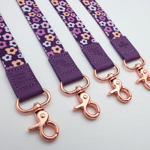 Floral-patterned leashes with purple accents and rose gold clasp on a light gray background