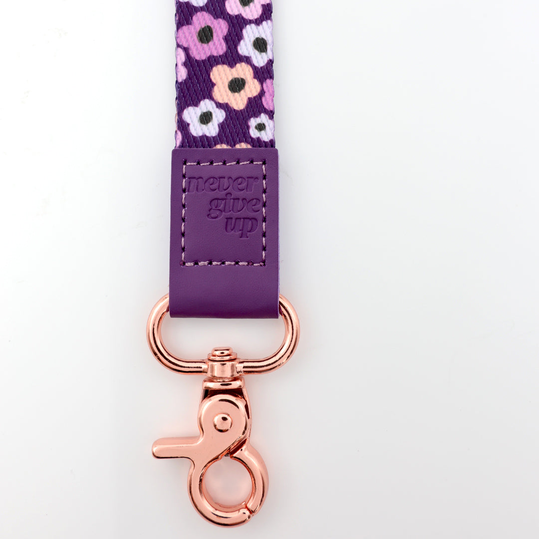 Floral-patterned lanyard with purple strap and rose gold clip on a white background