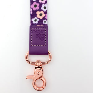Floral-patterned lanyard with purple strap and rose gold clip on a white background