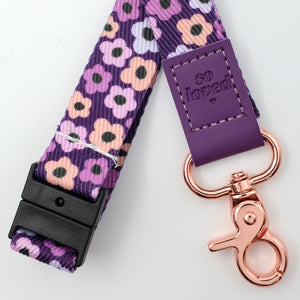 Floral patterned dog leash with purple buckle and rose gold clasp on a white background