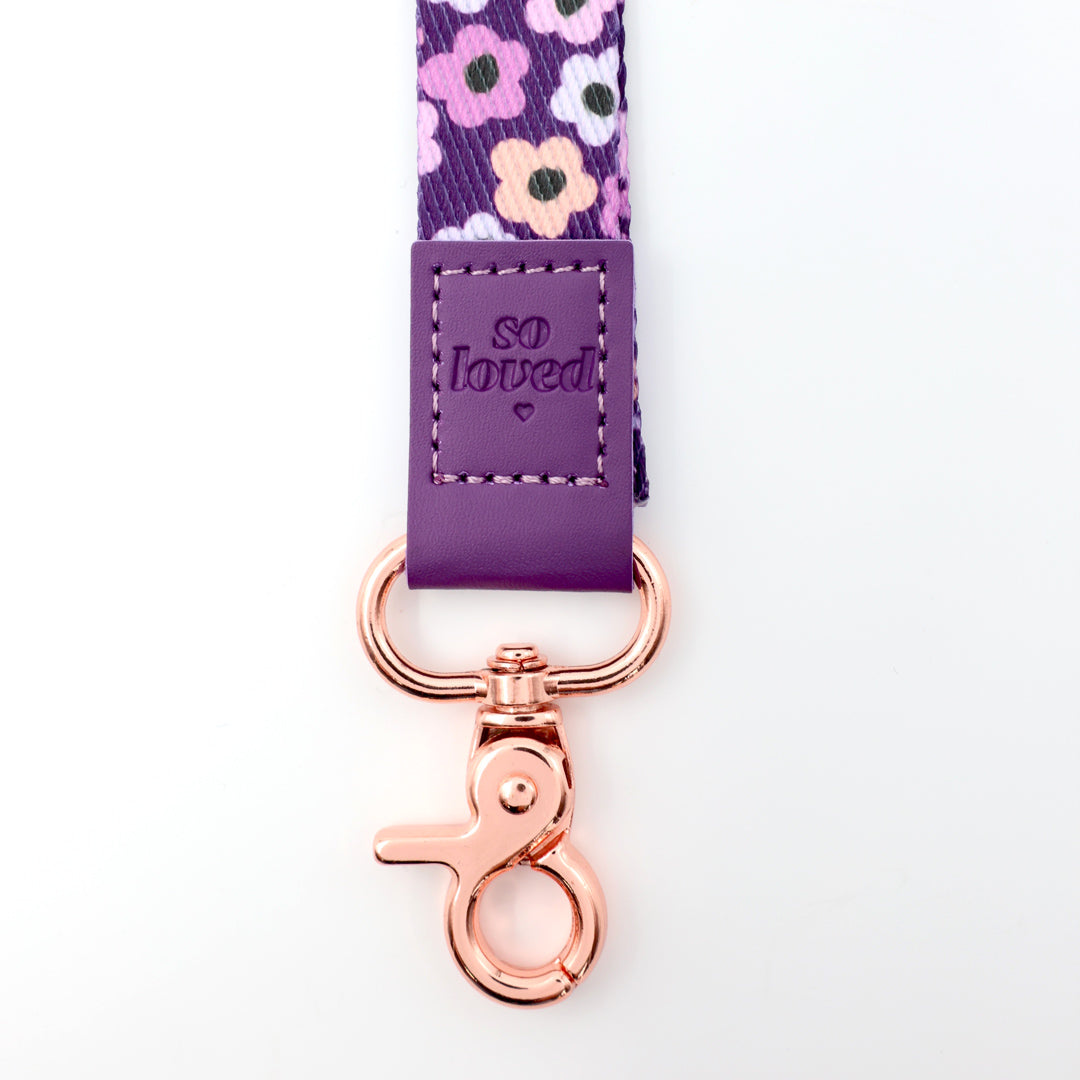 Floral ribbon with 'so loved' tag and rose gold clip on a white background
