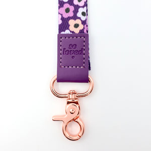 Floral ribbon with 'so loved' tag and rose gold clip on a white background