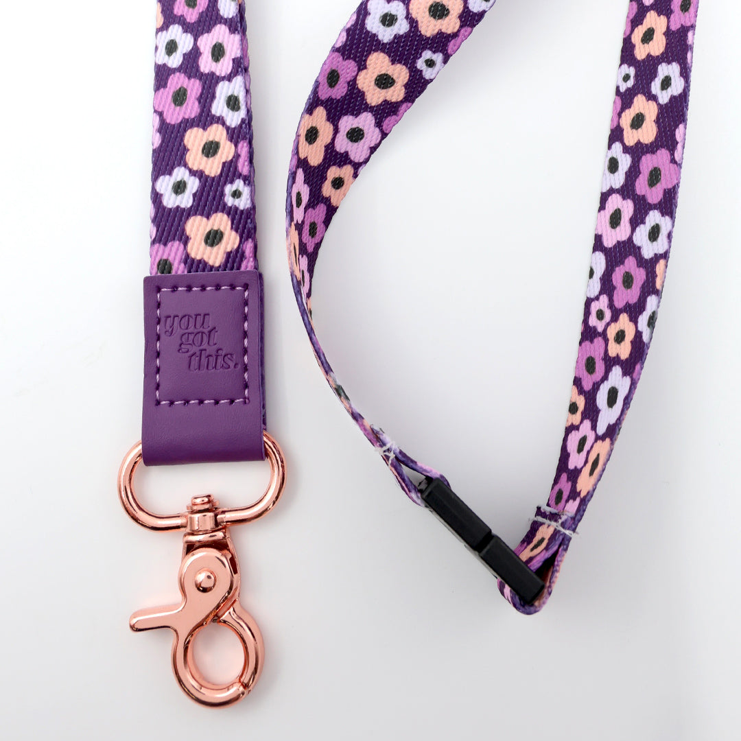 Floral patterned lanyard with purple strap and rose gold clasp on a white background