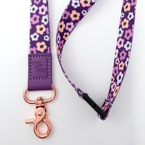 Floral patterned lanyard with purple strap and rose gold clasp on a white background