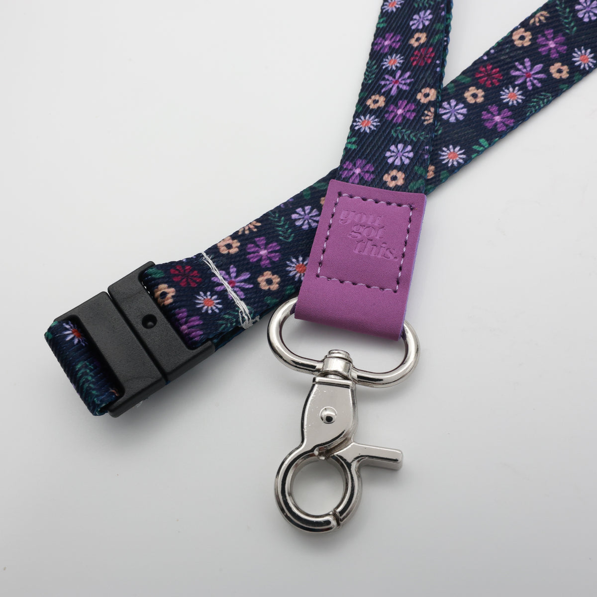 You Got This embossed on a navy floral lanyard with purple trim and a lobster clasp.