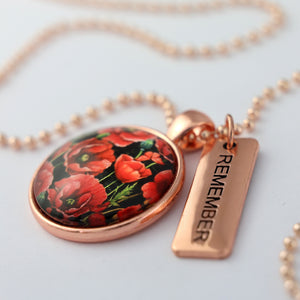 Necklace with floral pendant and 'REMEMBER' tag on a light background