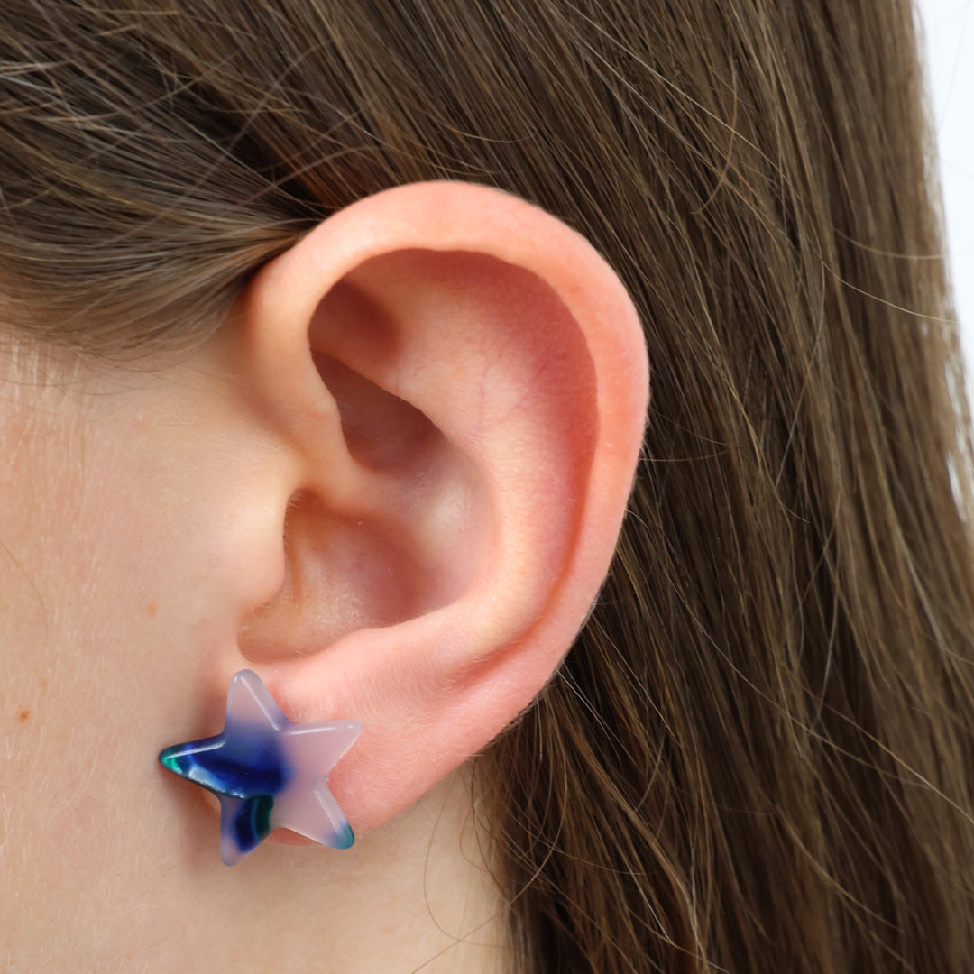 Two star-shaped stud earrings with a marbled blue, green, and white resin finish, displayed on a square card with the text 'SO LOVED' against a white background.