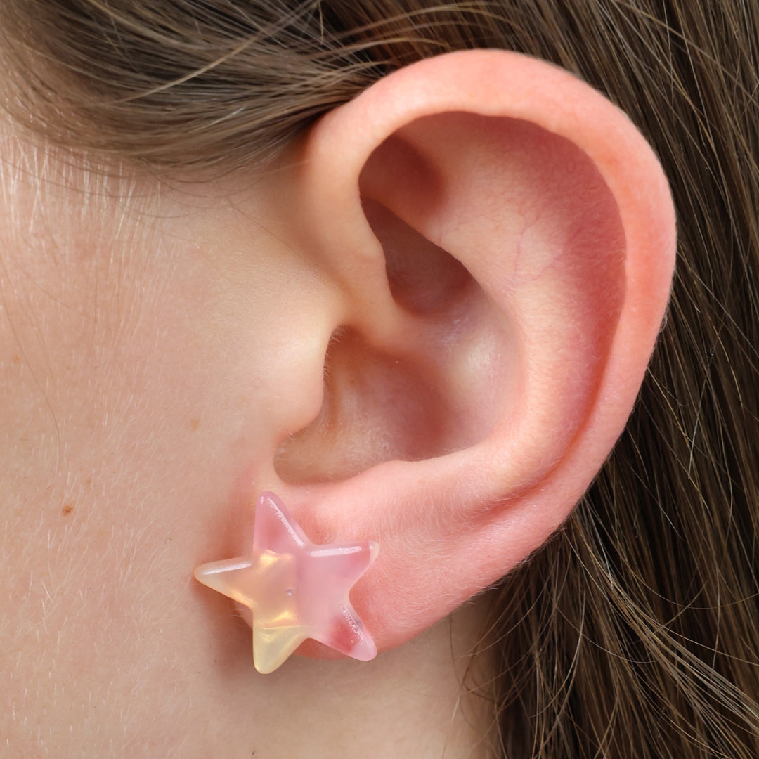 Star-shaped earring worn on a person's ear