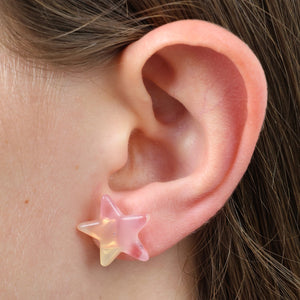 Star-shaped earring worn on a person's ear