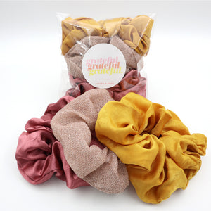 Set of colorful scrunchies with a 'grateful' label on a white background