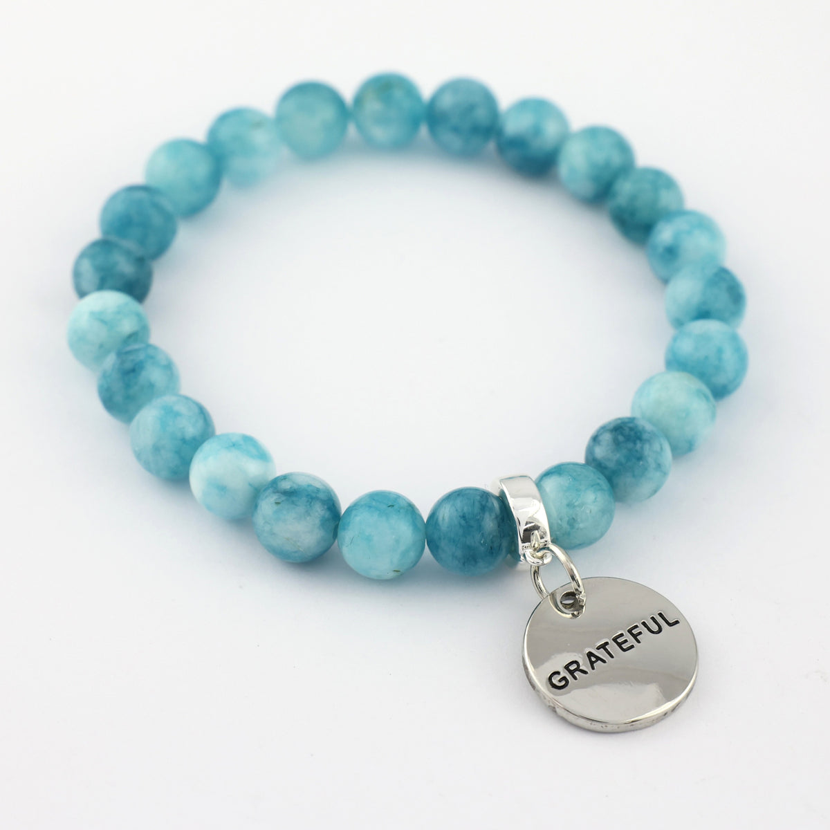 Turquoise beaded bracelet with a 'GRATEFUL' charm on a white background