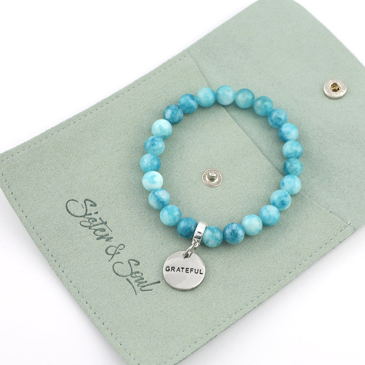 Turquoise beaded bracelet with 'Grateful' charm on a green card with 'Sister & Soul' branding.