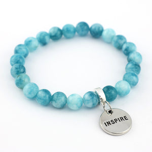 Blue beaded bracelet with a silver 'INSPIRE' charm on a white background