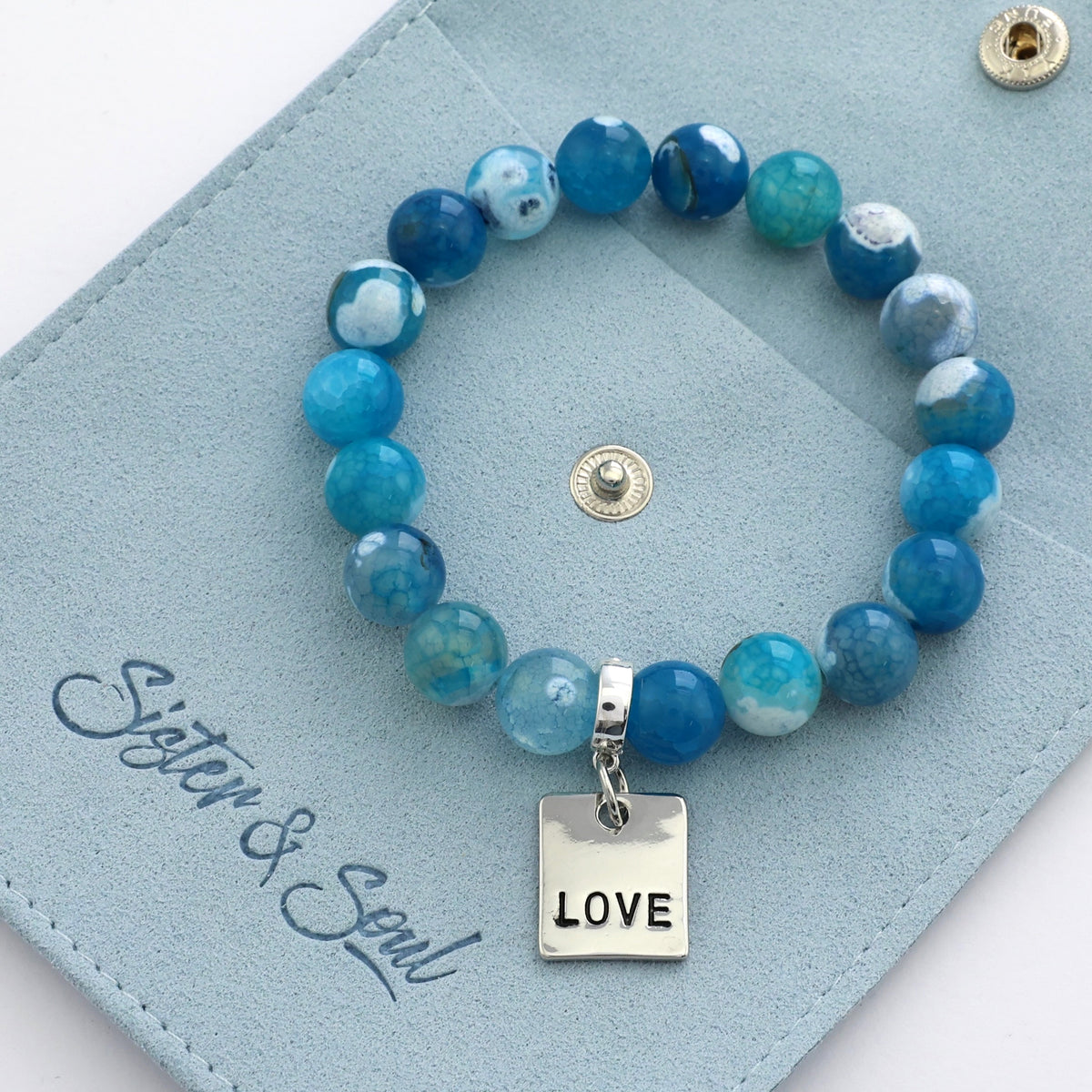 Blue beaded bracelet with 'LOVE' charm on a blue card with 'Sister & Soul' branding.