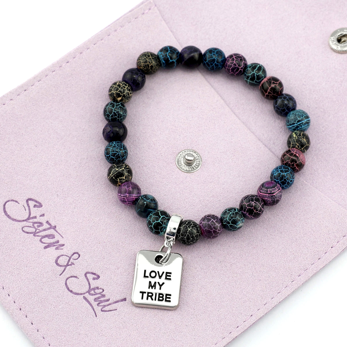 Multicolored beaded bracelet with 'Love My Tribe' charm on a pink card with 'Sister & Soul' branding.