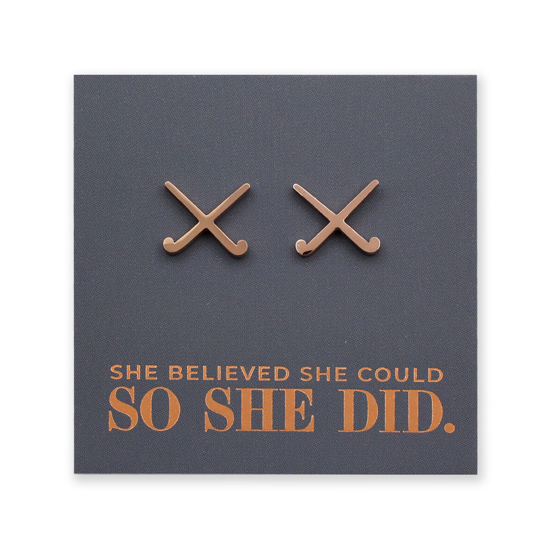 Rose Gold stainless steel hockey shaped earrings on a card with 'She believed she could so she did' text