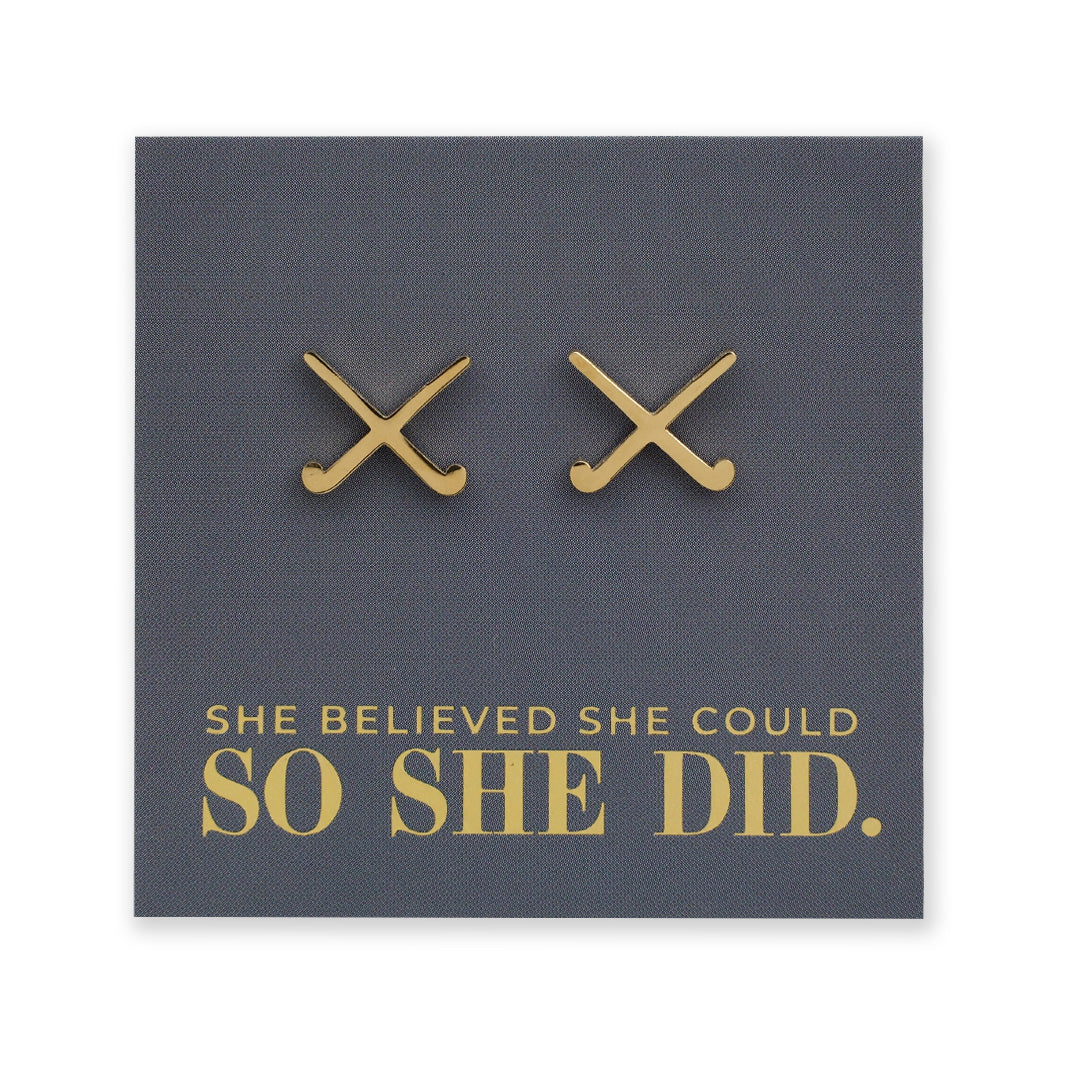 Gold stainless steel hockey shaped earrings on a dark grey card with 'She believed she could so she did' text