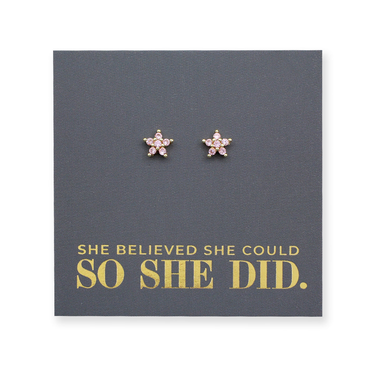 Pink cubic zirconia star shaped studs presented on a grey card with gold 'She Believed She Could So She Did' writing.