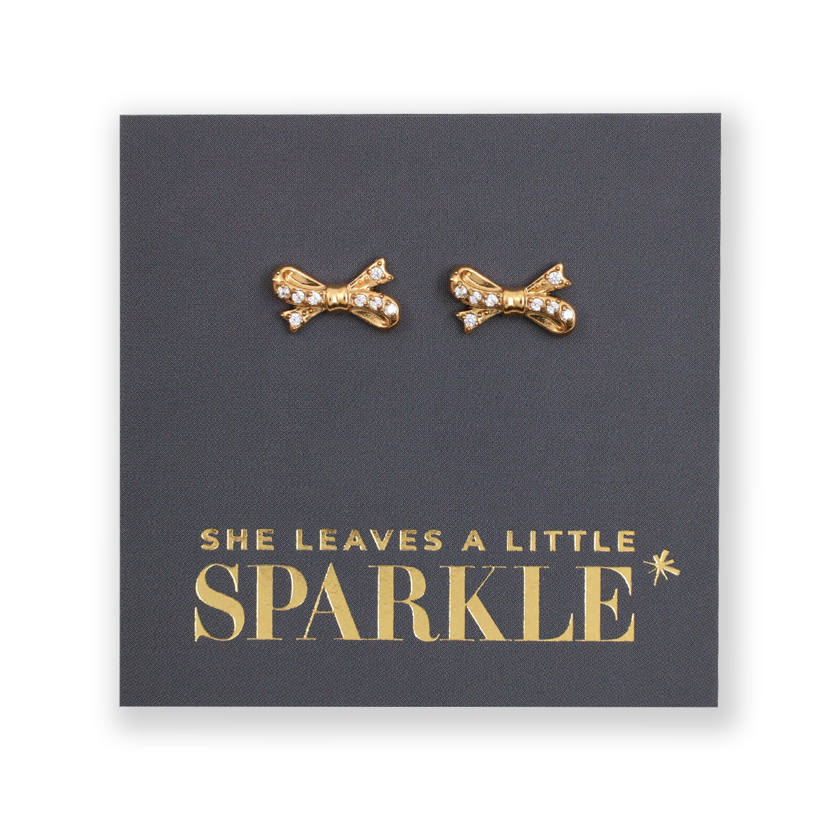 Gold bow shaped studs with clear gemstone features, on a card that says she leaves a little sparkle on a white background. 