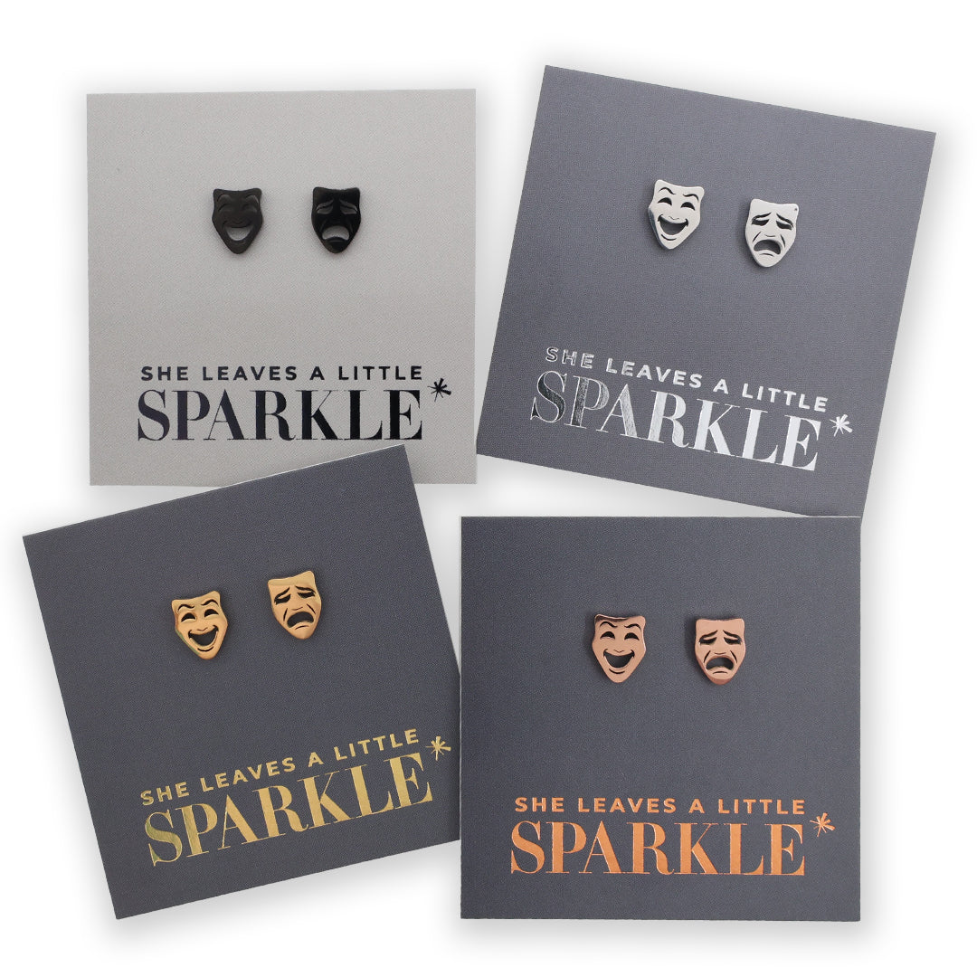 Four pairs of earrings on gray cards with 'She Leaves a Little Sparkle' text.