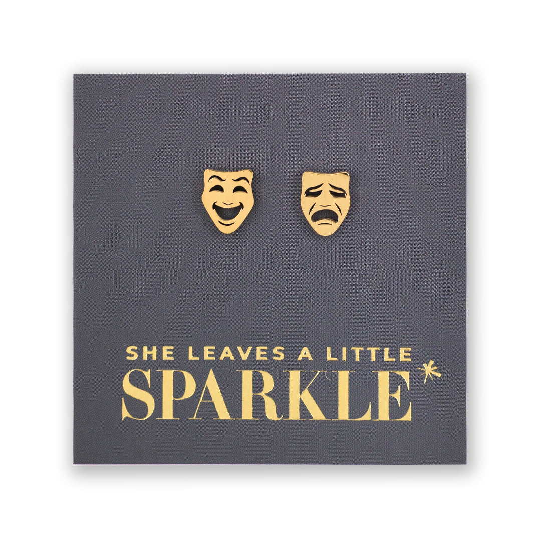 Gold theater mask earrings on a dark gray card with 'She Leaves a Little Sparkle' text.
