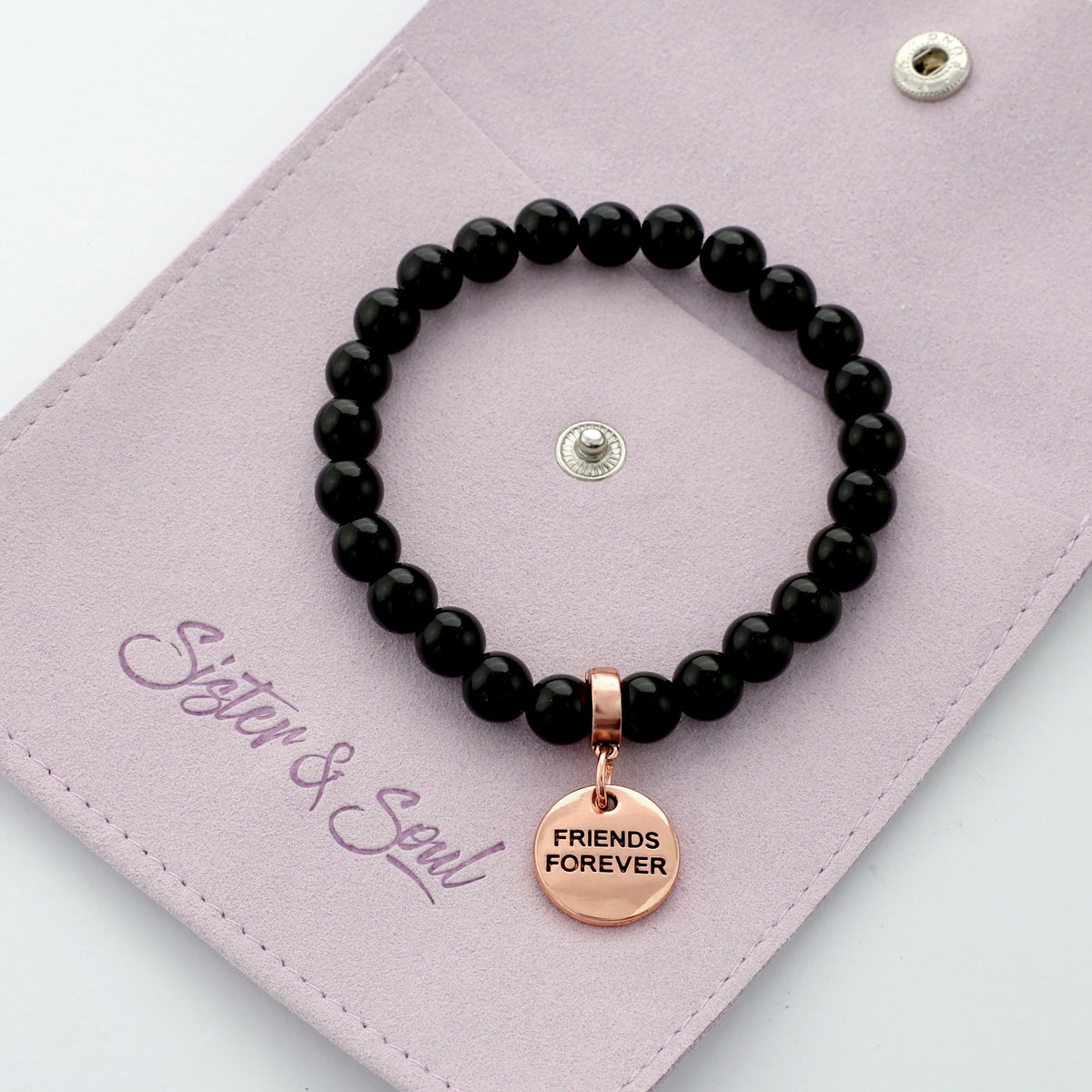Black beaded bracelet with 'Friends Forever' charm on a pink card with 'Sister & Soul' branding.