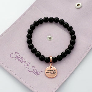 Black beaded bracelet with 'Friends Forever' charm on a pink card with 'Sister & Soul' branding.