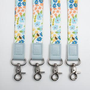 Sky Blue Floral lanyards showing Be Kind, Teach Love Inspire, You Got This and So Loved embossed trims and lobster clasps.