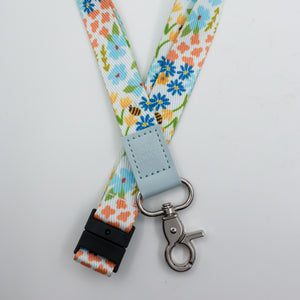 So Loved embossed on a colourful floral lanyard with pale blue trim and a lobster clasp.