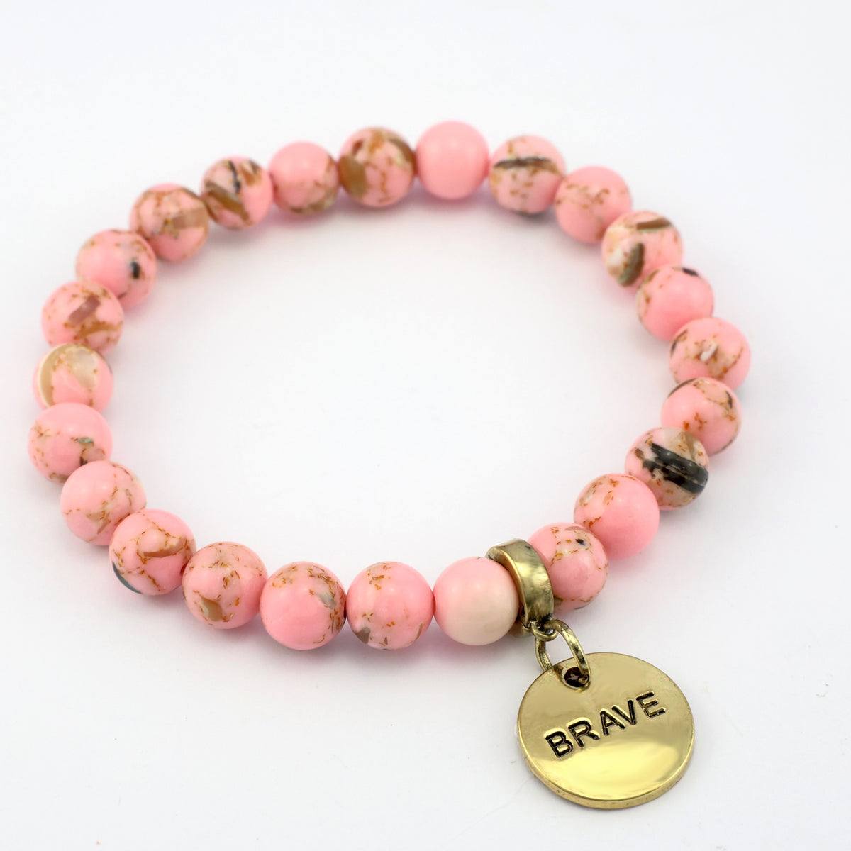Pink beaded bracelet with a gold 'BRAVE' charm on a white background