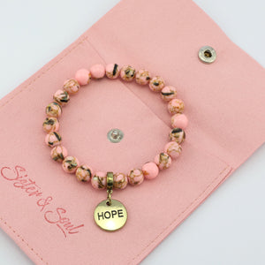 Beaded bracelet with 'HOPE' charm on a pink pouch