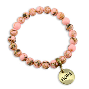 Pink beaded bracelet with a gold 'HOPE' charm on a white background
