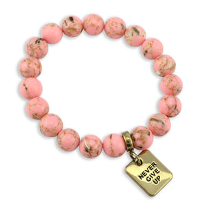 Pink beaded bracelet with a gold tag reading 'Never Give Up' on a white background