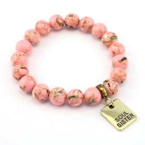 Pink beaded bracelet with a gold 'Soul Sister' tag on a white background