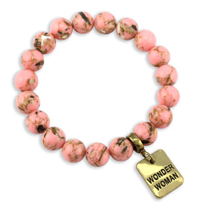 Pink beaded bracelet with a gold 'Wonder Woman' charm on a white background