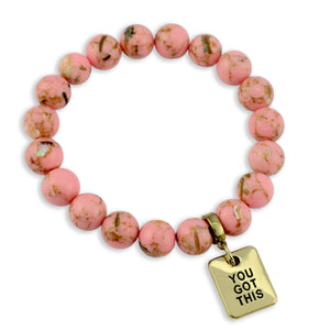 Pink beaded bracelet with a gold 'YOU GOT THIS' charm on a white background
