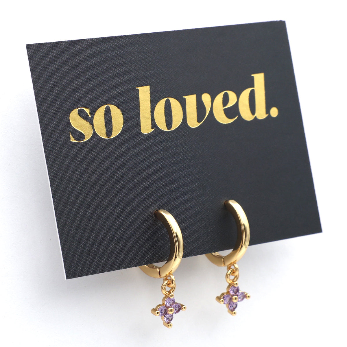 Gold hoop earrings with purple stones on a 'so loved' card