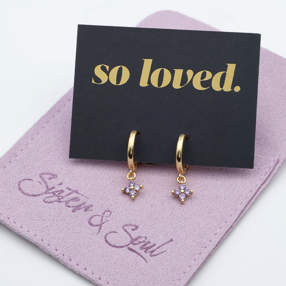 Gold hoop earrings with floral charms on a 'so loved' card by Sister & Soul.
