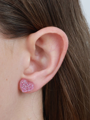 Girl You Are Amazing heart acrylic glitter stud earrings in light pink glitter worn on an ear to show size and fit