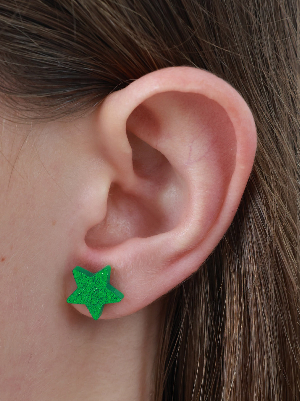Keep Shining star acrylic glitter stud earrings in green glitter worn on an ear to show size and fit